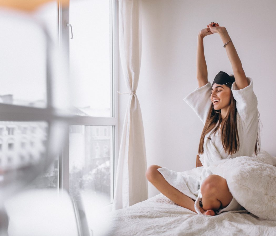 Woman in bed wearing sleeping mask
